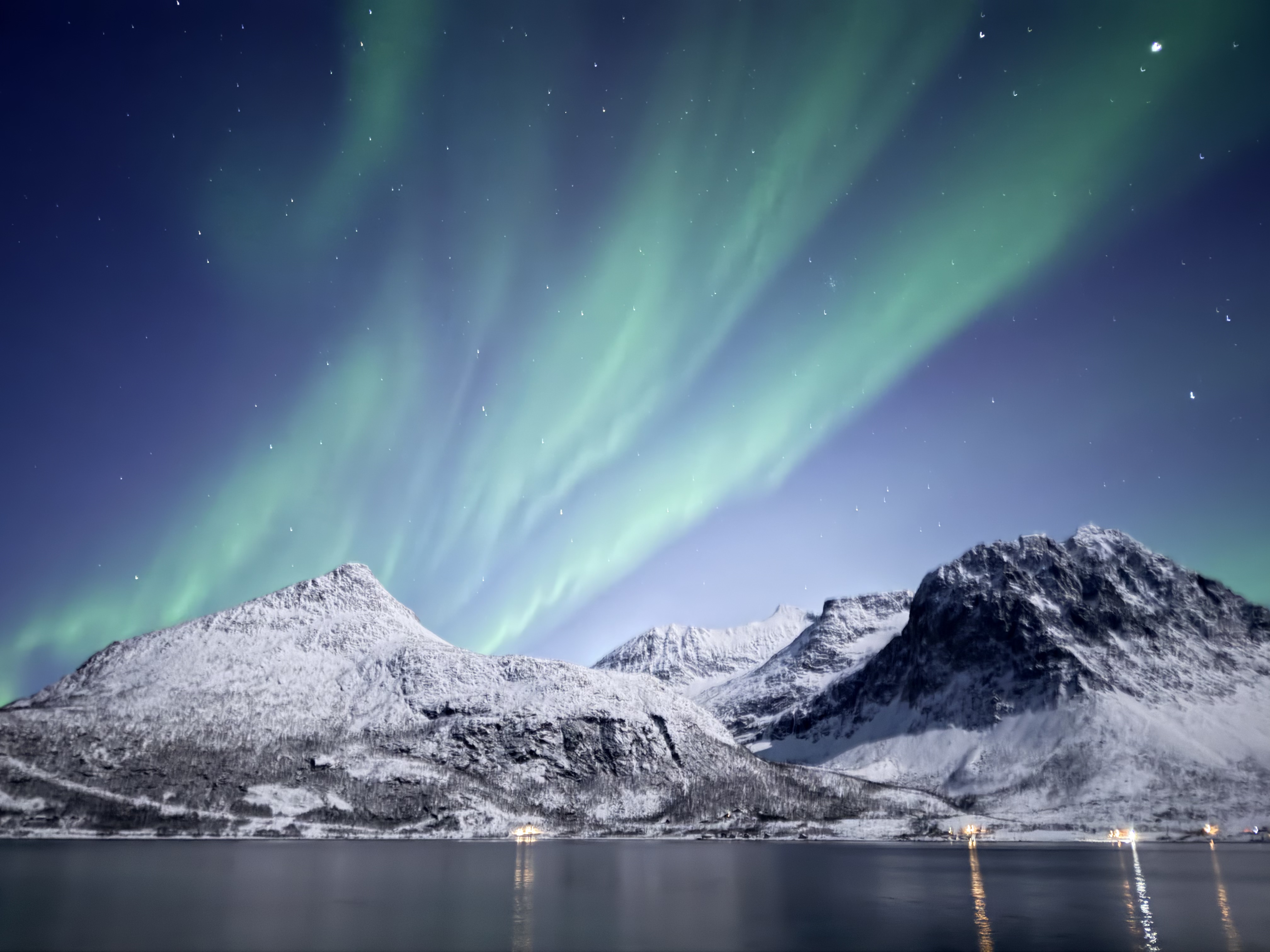 Aurora over fjord and mountain settlement