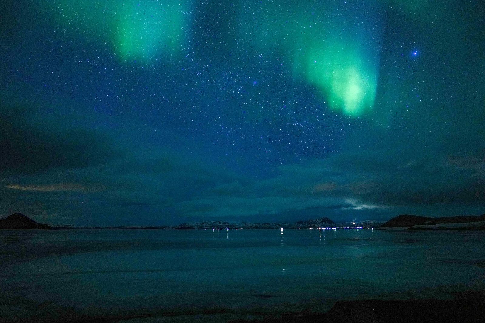 Green aurora over Lake Mývatn with a low cloud bank on the horizon
